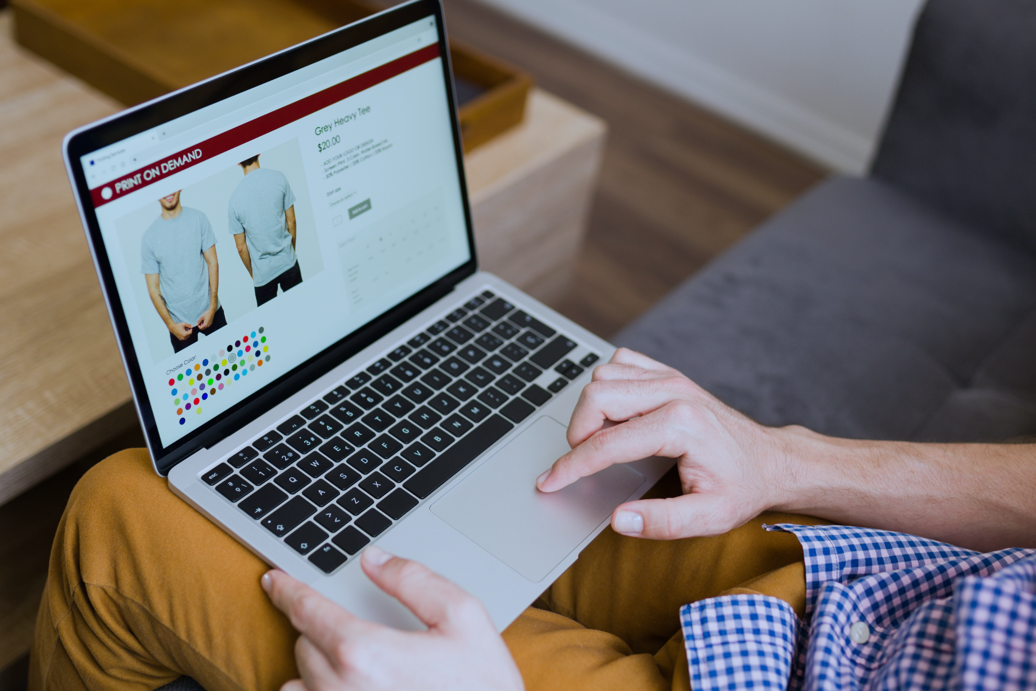Um homem sentado no sofá com um notebook em suas pernas fazendo comprar online.